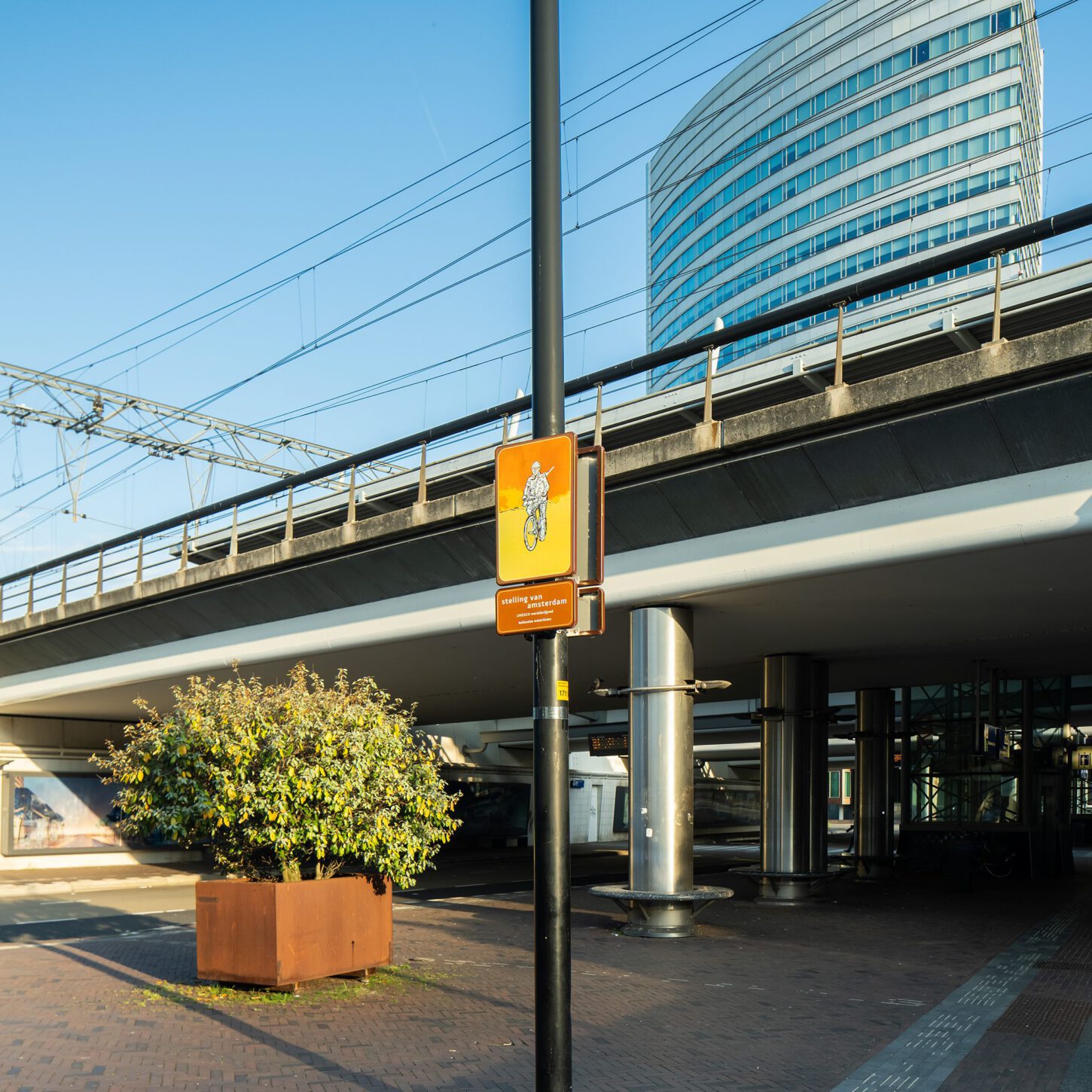 Beeldpaneel Soldaat op de fiets bij NS station Hoofddorp met spoorviaduct en kantoorgebouw op de achtergrond