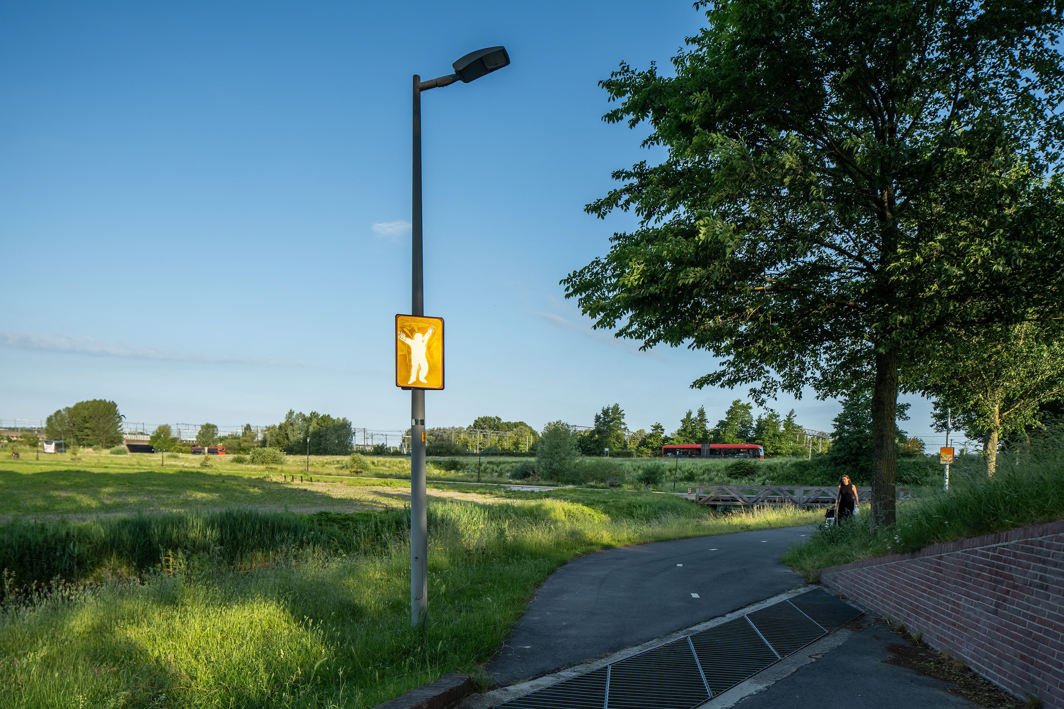 Beeldpaneel De Schreeuw langs de Geniedijk met open polderlandschap, fietspad en waterberging bij Hoofddorp