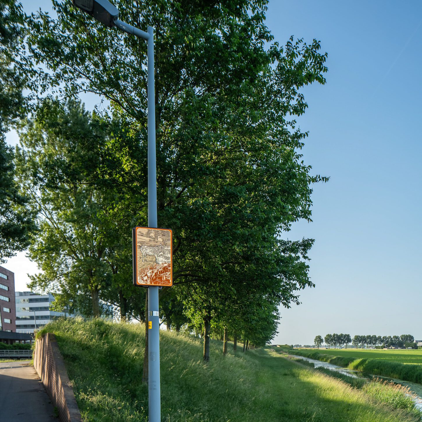 Beeldpaneel De ezel langs de Geniedijk met watergang en open polderlandschap van de Stelling van Amsterdam
