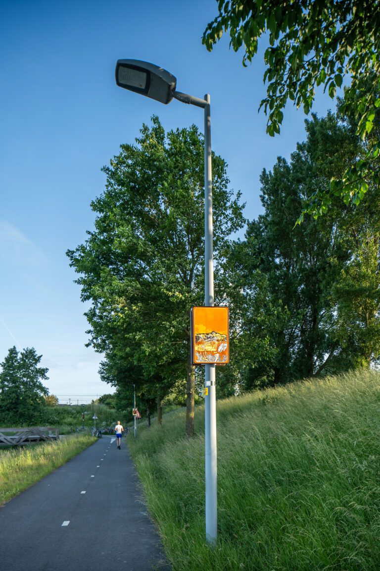 Beeldpaneel De golf langs de Geniedijk met hardloper op het fietspad en het landschap van de Stelling van Amsterdam