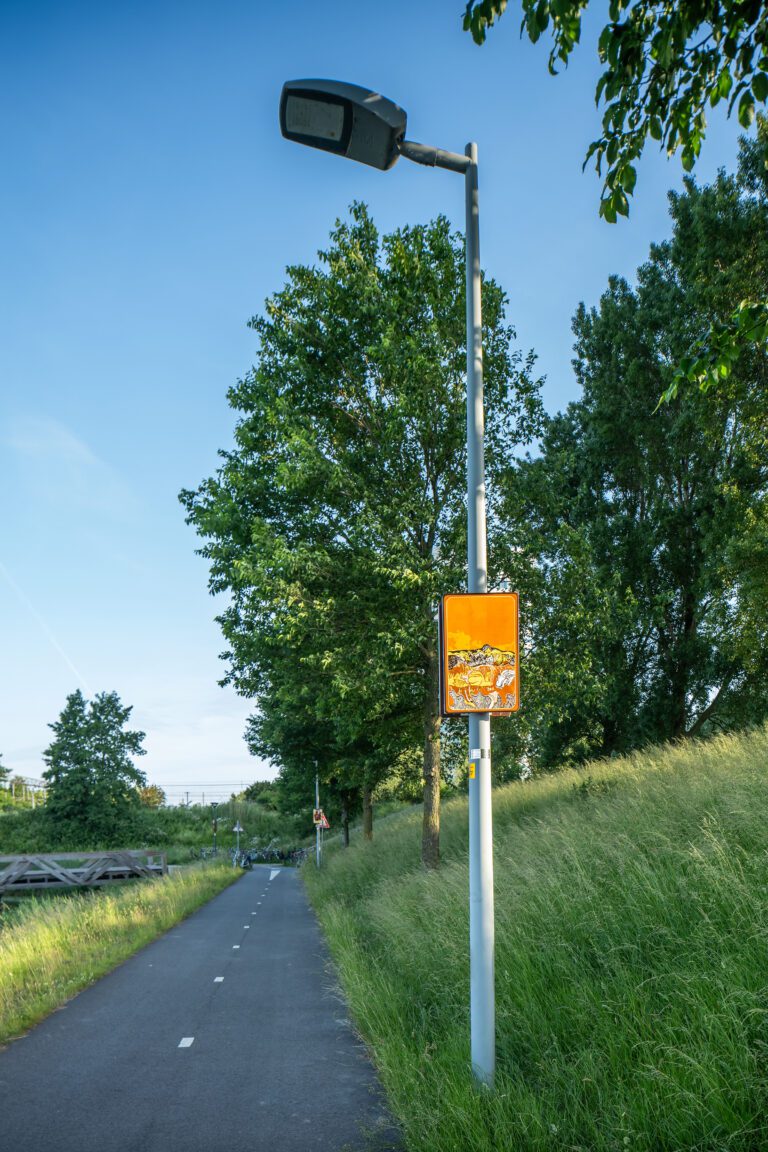 Beeldpaneel De golf langs de Geniedijk met fietspad, grasdijk en landschap van de Stelling van Amsterdam
